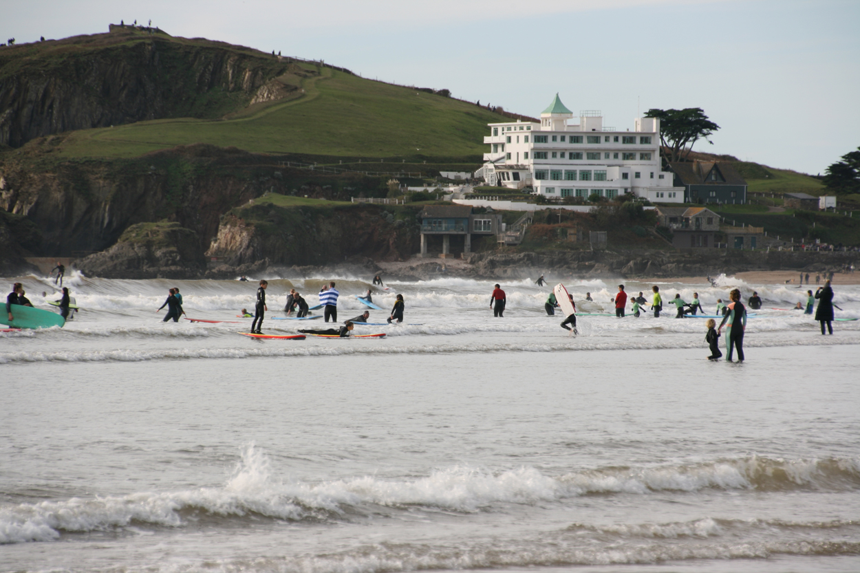 Surfers in the sea beneath Burgh Island